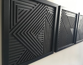 May include: Three black framed wall art pieces with a geometric pattern of overlapping lines creating a 3D effect.