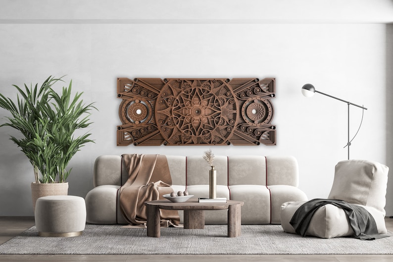 Puede incluir: Una pieza de arte de pared de madera marr&oacute;n con un dise&ntilde;o geom&eacute;trico. La pieza de arte est&aacute; colgada sobre un sof&aacute; blanco con una manta de tiro marr&oacute;n. Hay una mesa peque&ntilde;a delante del sof&aacute; con un jarr&oacute;n de flores encima.