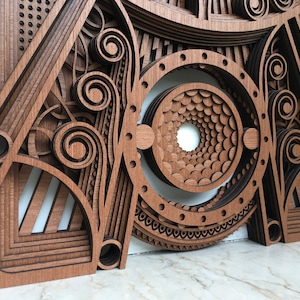 Puede incluir: Un primer plano de una pieza de arte de pared de madera con intrincados patrones geom&eacute;tricos y un dise&ntilde;o circular en el centro. La pieza est&aacute; hecha de m&uacute;ltiples capas de madera, creando un efecto 3D.