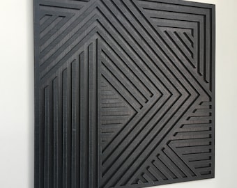 May include: A square, black wooden wall art piece with a geometric design. The artwork features a series of angled lines and shapes, creating a layered, textured effect. The piece is mounted on a white wall, showcasing the contrast between the art and the background.