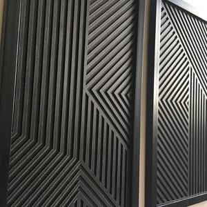 Könnte beinhalten: Zwei schwarze gerahmte Wandbilder mit einem geometrischen Muster aus überlappenden Linien, die einen 3D-Effekt erzeugen.