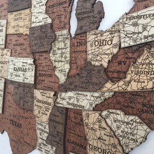 May include: A wooden map of the United States with each state outlined and labelled. The map is made of different shades of brown wood and has a vintage look.