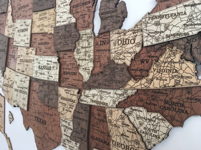 May include: A wooden map of the United States with each state outlined and labelled. The map is made of different shades of brown wood and has a vintage look.