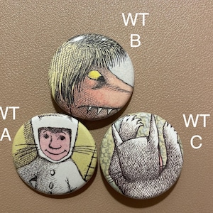 Può includere: Tre bottoni rotondi con diverse illustrazioni. Il primo bottone presenta una creatura bianca con un cappello a strisce bianche e nere e un viso giallo. Il secondo bottone presenta una creatura bianca e nera con un occhio giallo. Il terzo bottone presenta una creatura bianca e nera con un corpo grigio e un viso bianco.