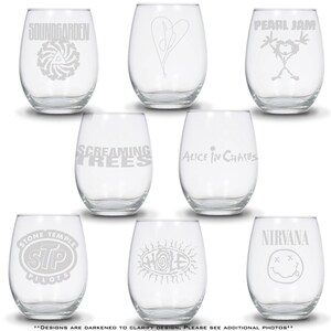 May include: A set of eight clear stemless wine glasses, each featuring a unique etched logo or symbol from various rock bands including Soundgarden, Pearl Jam, Screaming Trees, Alice in Chains, Stone Temple Pilots, Hole, and Nirvana.
