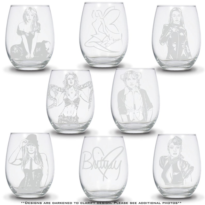 May include: Set of nine wine glasses with etched designs featuring a pop star. The glasses feature different images of the pop star, including a fairy, a signature, and various outfits. The text "Britney" is etched on one of the glasses.