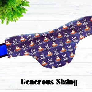 May include: A navy blue dog bandana with a repeating pattern of a dog in a floatie with the text "Just Chillin'". The bandana has a blue strap and the text "Generous Sizing" at the bottom.