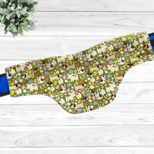 May include: Green dog bandana with a pattern of white dogs, flowers, and hearts on a green background.