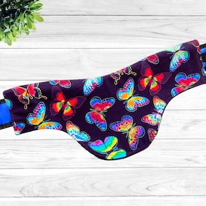 May include: A black fabric neck wrap with a colorful butterfly pattern. The wrap is made of soft, comfortable fabric and is perfect for keeping your neck warm in the winter.