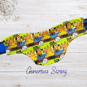 May include: A bright lime green fanny pack featuring a repeating cartoon print of a dog sitting in a room filled with fire. Each dog is depicted with a speech bubble containing the text This is fine. The bag has dark blue straps on each side.