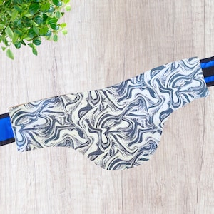 May include: A white and black marbled fabric neck warmer with blue trim.