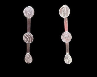 Long hand crafted sterling silver bar earrings embellished with circles and a teardrop.