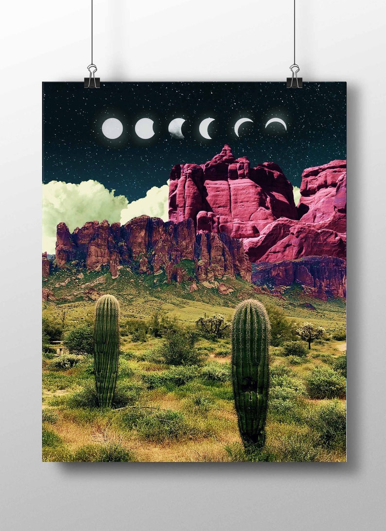 May include: A digital art print featuring a desert landscape with two tall cacti in the foreground. The background shows a mountain range with a pink hue and a night sky with a series of white crescent moons.