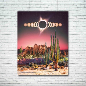 May include: A digital art print featuring a desert landscape with tall cacti and a red sky. The sun is partially eclipsed by the moon, with a ring of light around it. The print has a retro, psychedelic vibe.