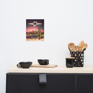 May include: A digital illustration of a desert landscape with a series of moons and a solar eclipse in the sky. The landscape features cacti and rock formations.