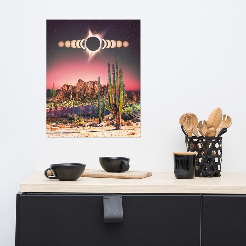 May include: A digital art print featuring a desert landscape with a red sky and a large cactus in the foreground. The sky is filled with a solar eclipse, with the sun's rays radiating out from the center. The print is perfect for adding a touch of nature to any room.