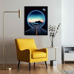 May include: A digital art print featuring a road leading into a glowing blue circle with a crescent moon and stars in the night sky. The print is framed and hanging on a white wall in a living room setting.