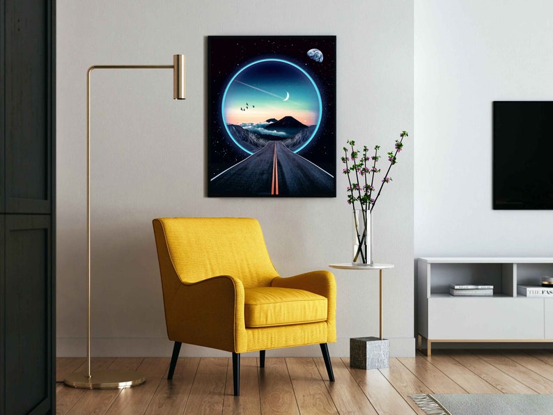 May include: A digital art print featuring a road leading into a glowing blue circle with a crescent moon and stars in the night sky. The print is framed and hanging on a white wall in a living room setting.
