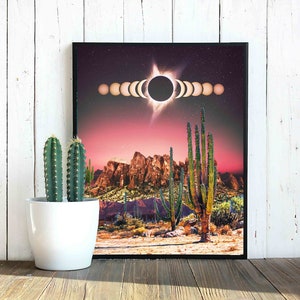 May include: A digital art print featuring a desert landscape with a red sky and a large black sun with a white halo. The sun is surrounded by a series of smaller circles, representing the phases of the moon. The desert landscape includes tall cacti and mountains in the background.