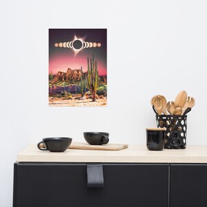 May include: A digital art print featuring a desert landscape with tall cacti and a dramatic sunset. The sun is partially eclipsed by the moon, creating a ring of light in the sky. The print is perfect for adding a touch of nature and celestial beauty to any room.