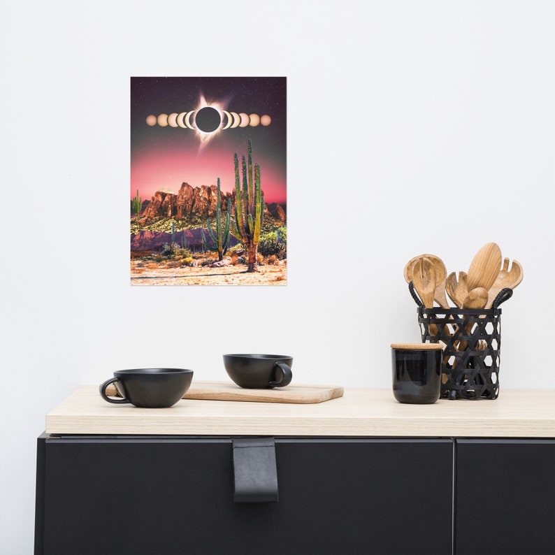 May include: A digital art print featuring a desert landscape with tall cacti and a dramatic sunset. The sun is partially eclipsed by the moon, creating a ring of light in the sky. The print is perfect for adding a touch of nature and celestial beauty to any room.