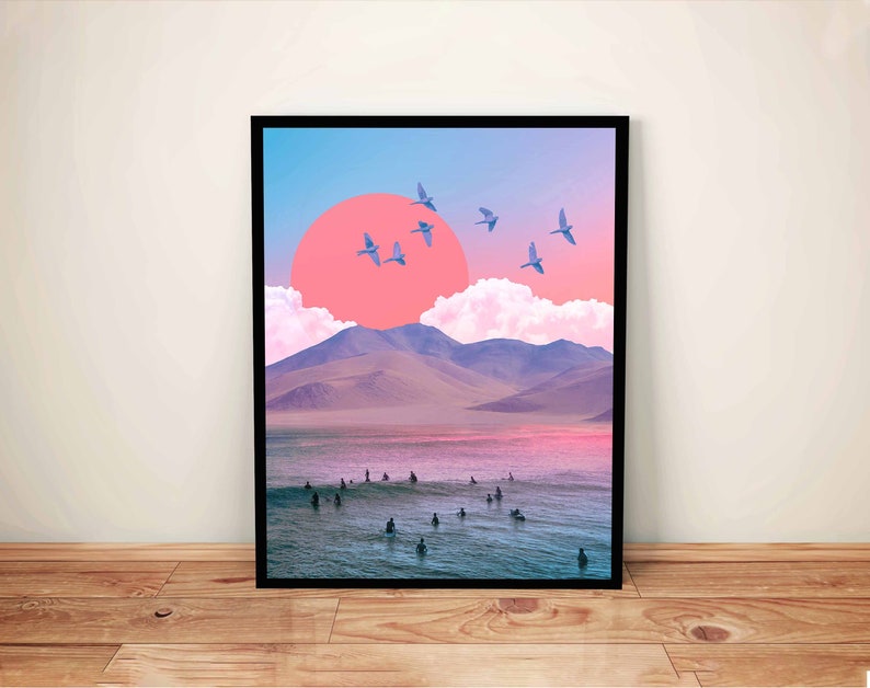 May include: A digital art print featuring a pink sunset over a mountain range with a flock of birds flying overhead. The scene is reflected in the water below, where people are surfing.