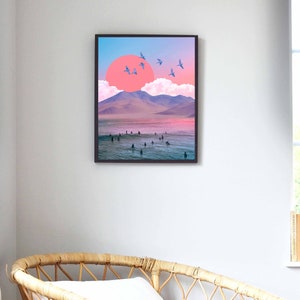 May include: A digital art print featuring a pink and blue sunset over a mountain range with a group of surfers in the water. The print is framed in black.