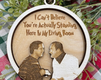 May include: A circular wooden Christmas decoration featuring the text "I Can't Believe You're Actually Standing Here In My Living Room" and two figures. The ornament is natural wood-toned with a white border and a twine loop.
