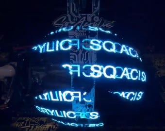 May include: A black car with a blue neon light display that reads "CYLICSQUAD" and "CYLICS" on the back of the car.