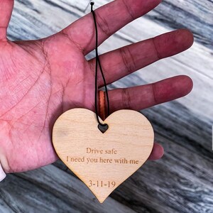 May include: Wooden heart-shaped ornament with the text "Drive safe I need you here with me 3-11-19" engraved on it.