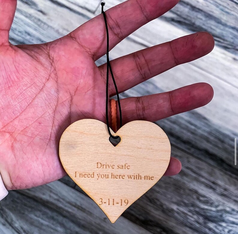 May include: Wooden heart-shaped ornament with the text "Drive safe I need you here with me 3-11-19" engraved on it.