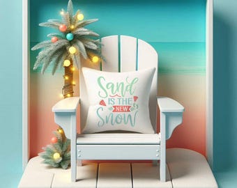 May include: A white Adirondack chair with a pillow that reads "Sand is the New Snow" sits in a white frame. A small palm tree with string lights and colorful ornaments is to the left of the chair. The background is a beach scene.