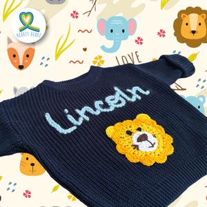 May include: A white ceramic mug with a black handle and the text "But First, Coffee" in a bold, black font. The mug is set against a blurred background, suggesting a cozy setting.