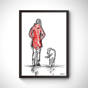 Op de afbeelding: Een ingelijste kunstdruk met een persoon in een rode jas en een hond. De schets is in zwart-wit met rode accenten, wat een minimalistische stijl laat zien. Het kunstwerk legt een moment van kameraadschap vast.