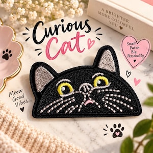 Könnte beinhalten: Ein gestickter Aufnäher in Form eines schwarzen Katzenkopfes mit gelben Augen, grauen Innenohren und weißen Schnurrhaaren. Der Aufnäher ist von Texten wie Curious Cat, Meow Good Vibes und Small Patch Big Personality sowie Herzsymbolen umgeben.