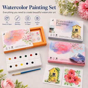 Könnte beinhalten: Ein Aquarell-Malset bestehend aus drei rechteckigen Schachteln mit Blumen- und Landschaftsmotiven, einer weißen Kunststoffpalette mit zwölf runden Farbnäpfchen und einem einzelnen Pinsel mit blauem Stiel und goldener Zwinge.