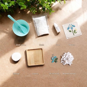 May include: An assortment of craft supplies, including a teal bowl and spoon, a small wooden coaster, a sponge, and packets of caulk and glue. Additional elements include a floral pattern, accessories, and beveled mosaic pieces. The items are arranged on a brown surface.