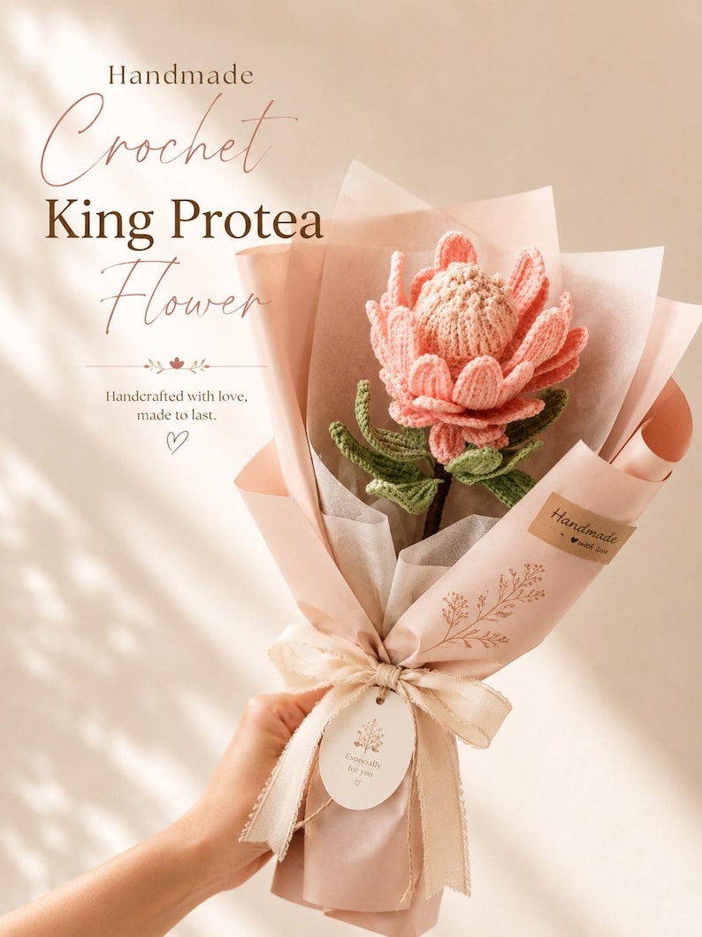 May include: A single crocheted King Protea flower with pink petals and green leaves, wrapped in light pink paper with a ribbon and a tag that reads Especially for you. The text Handmade Crochet King Protea Flower is visible.