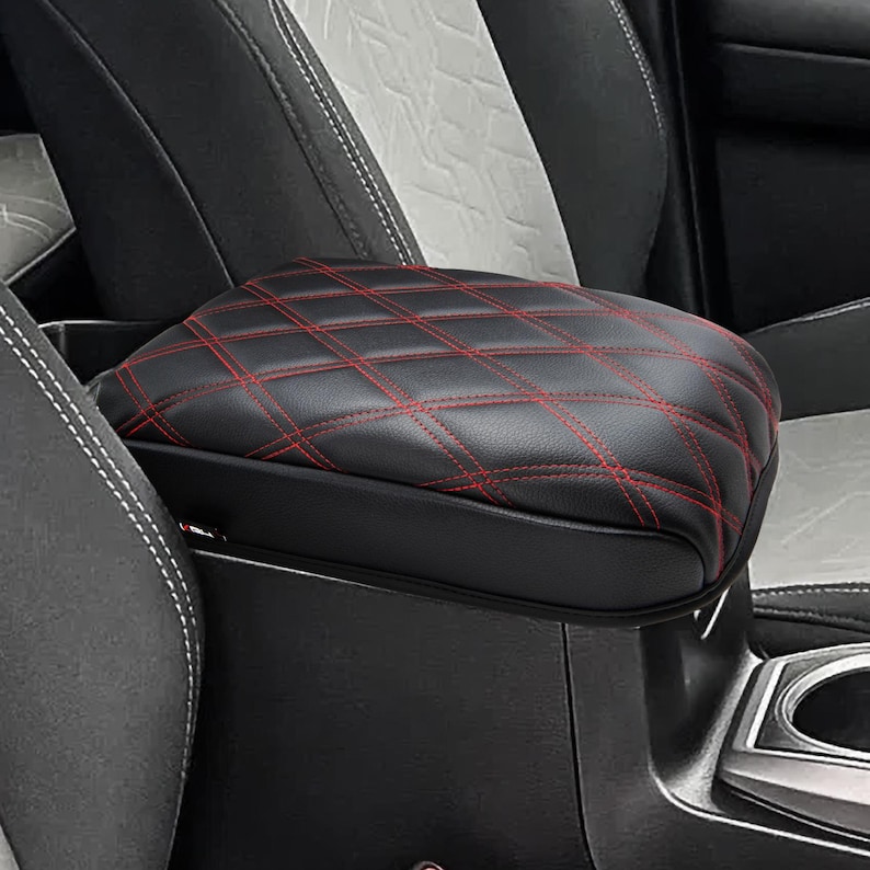 Peut inclure: Couvre-accoudoir de voiture en cuir noir avec surpiq&ucirc;res rouges et un motif en losange.