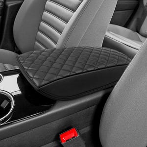 May include: Black quilted leather car seat armrest cover. The cover is designed to fit over the existing armrest and provides a comfortable and stylish addition to the interior of the car.
