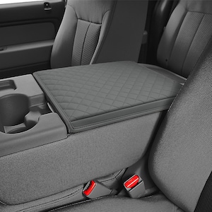 May include: Gray quilted center console armrest cover for a car. The cover is made of a soft, durable material and has a diamond-stitched pattern.