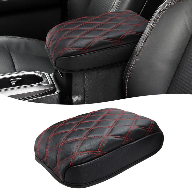 Peut inclure: Accoudoir de voiture en cuir noir avec un motif en losange rouge. L'accoudoir est rembourr&eacute; et a une surface lisse.
