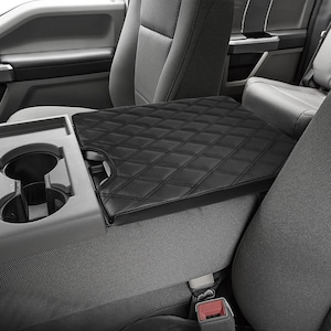 May include: Black quilted leather center console armrest cover for a car. The cover has a diamond pattern and is designed to protect the armrest from wear and tear.