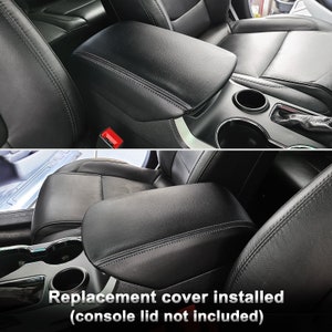 May include: Black leather replacement console lid cover installed in a car interior. The cover is stitched with a contrasting thread and fits over the existing console. Text on the image reads: "Replacement cover installed (console lid not included)".