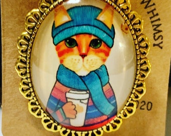 Kat in sjaal en hoed met koffie,30x40 mm ovale beeldspeld, kattenspeld, kattenbroche, p kat met koffiespeld