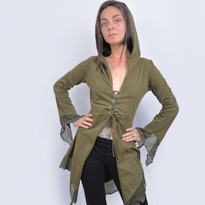 Könnte beinhalten: Eine langärmelige, olivgrüne Kapuzen-Tunika mit Schnürung vorne und einem fließenden, asymmetrischen Saum. Die Tunika hat transparente, spitzenstichelige Details an den Ärmeln und am Saum.