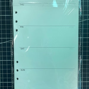 May include: A light green weekly planner page with a plastic cover. The page has four sections labeled "THU", "FRI", "SAT", and "SUN".