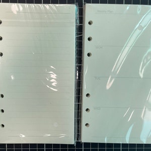 May include: Two blank white pages for a planner or notebook. One page is lined and the other has the text "Weekly Plan" and the days of the week: Monday, Tuesday, Wednesday.