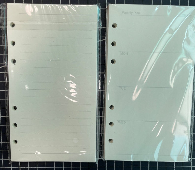 May include: Two blank white pages for a planner or notebook. One page is lined and the other has the text "Weekly Plan" and the days of the week: Monday, Tuesday, Wednesday.