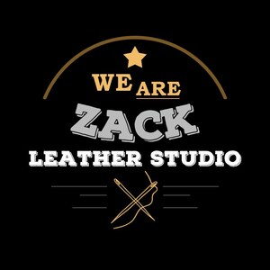 May include: A black logo featuring the text "WE ARE ZACK LEATHER STUDIO" in white, grey, and gold. A gold star and a curved line are above the text. Below the text is a crossed needle and thread.